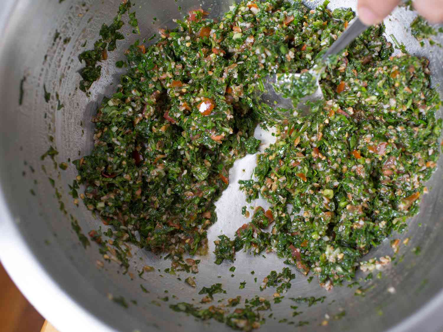 Dragging a spoon through a bowl of tabbouleh.