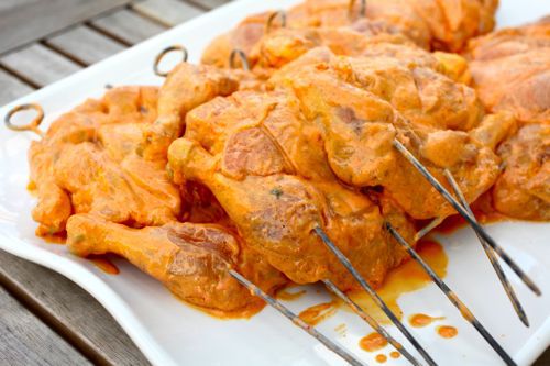 A platter piled high with Cornish hens, skewered, marinated, and ready for the grill.