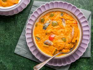 A bowl of Nigerian egg sauce served on a green placemat with a spoon