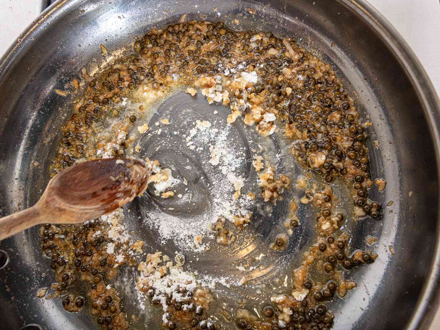 flour added into peppercorn mixture on skillet
