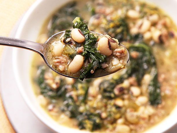 Closeup of spoonful of sausage, kale, and black-eye pea soup