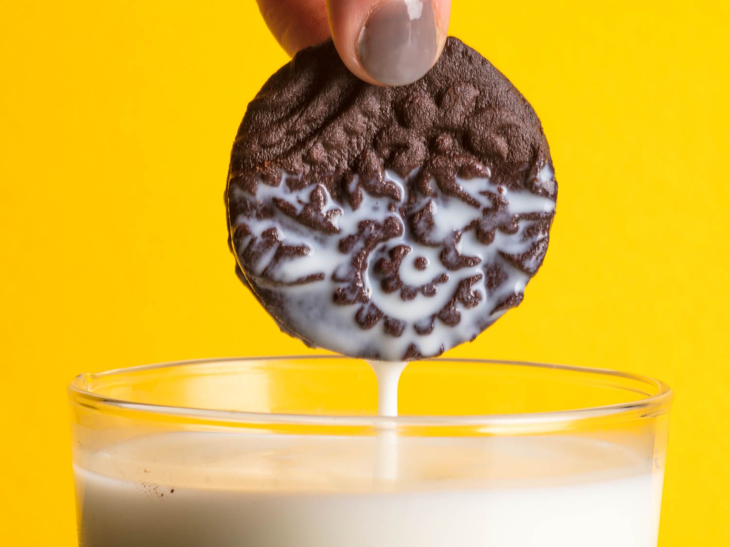 Dunking a homemade Oreo cookie into a glass of milk.
