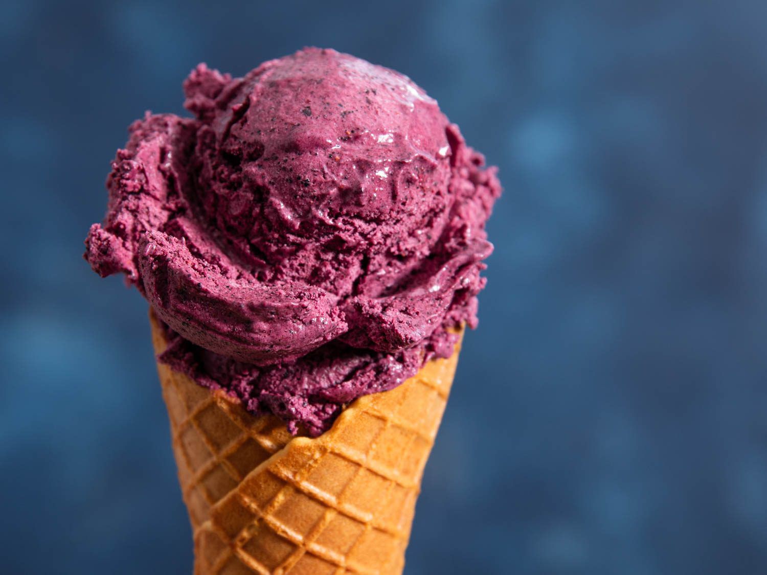 Blueberry ice cream in a cone.