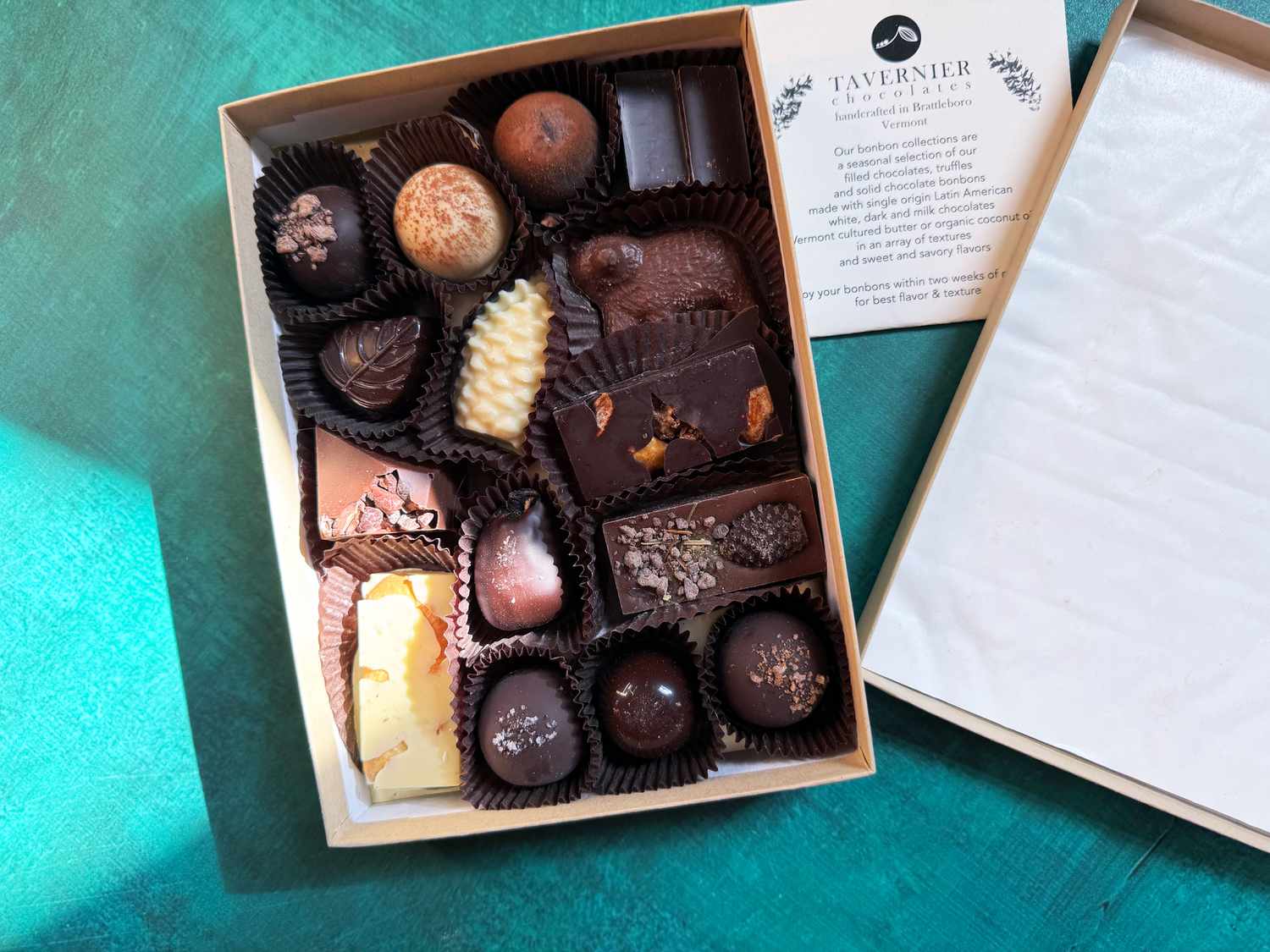 Tavernier chocolates with box open on a teal background