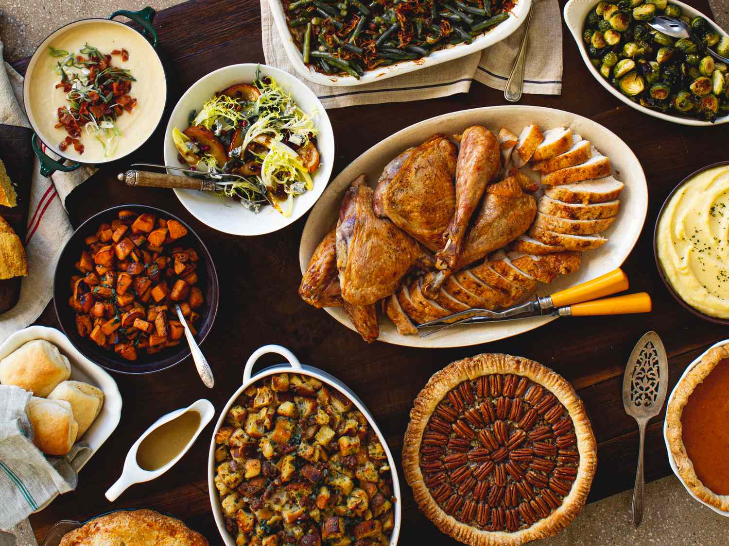 Traditional Thanksgiving dinner with roasted turkey stuffing mashed potatoes green beans and assorted side dishes and desserts