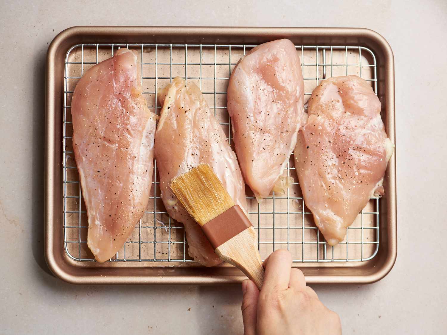 Brushing chicken breasts lightly with remaining 2 tablespoons of oil 