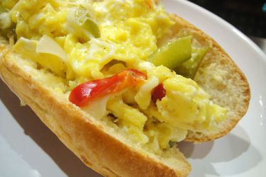 A Peppers and Eggs Sandwich on a white plate. 