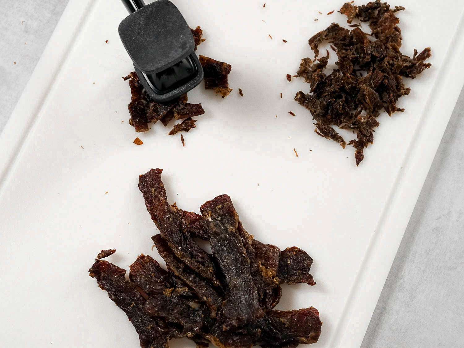 Overhead view of pounding dried beef with a mallet to make machaca.