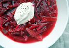 A bowl of vegetarian borscht with a dollop of sour cream on top. 