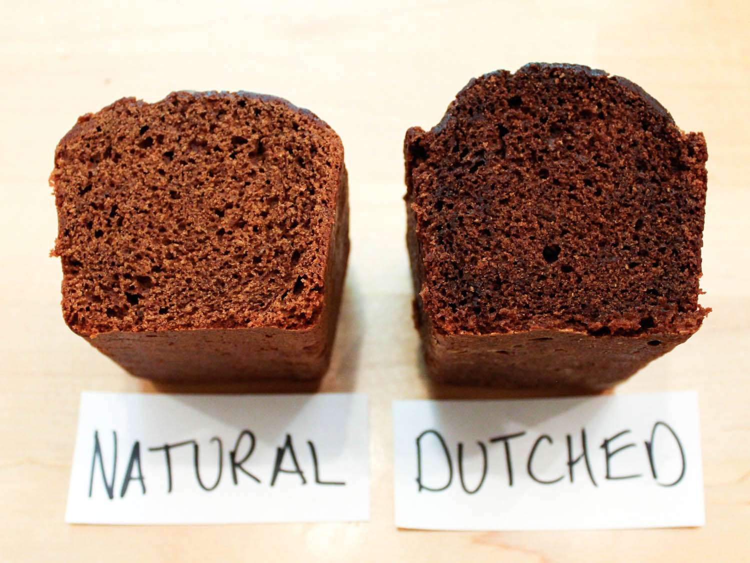 Side by side cross-sections of chocolate cakes baked with natural and Dutch cocoa
