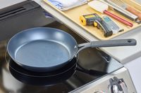The OXO Obsidian 10 Inch Pre-Seasoned Carbon Steel Frying Pan on a stovetop
