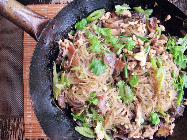 Overhead view of Glass Noodles with Chicken and Mushrooms, served straight from a wok.