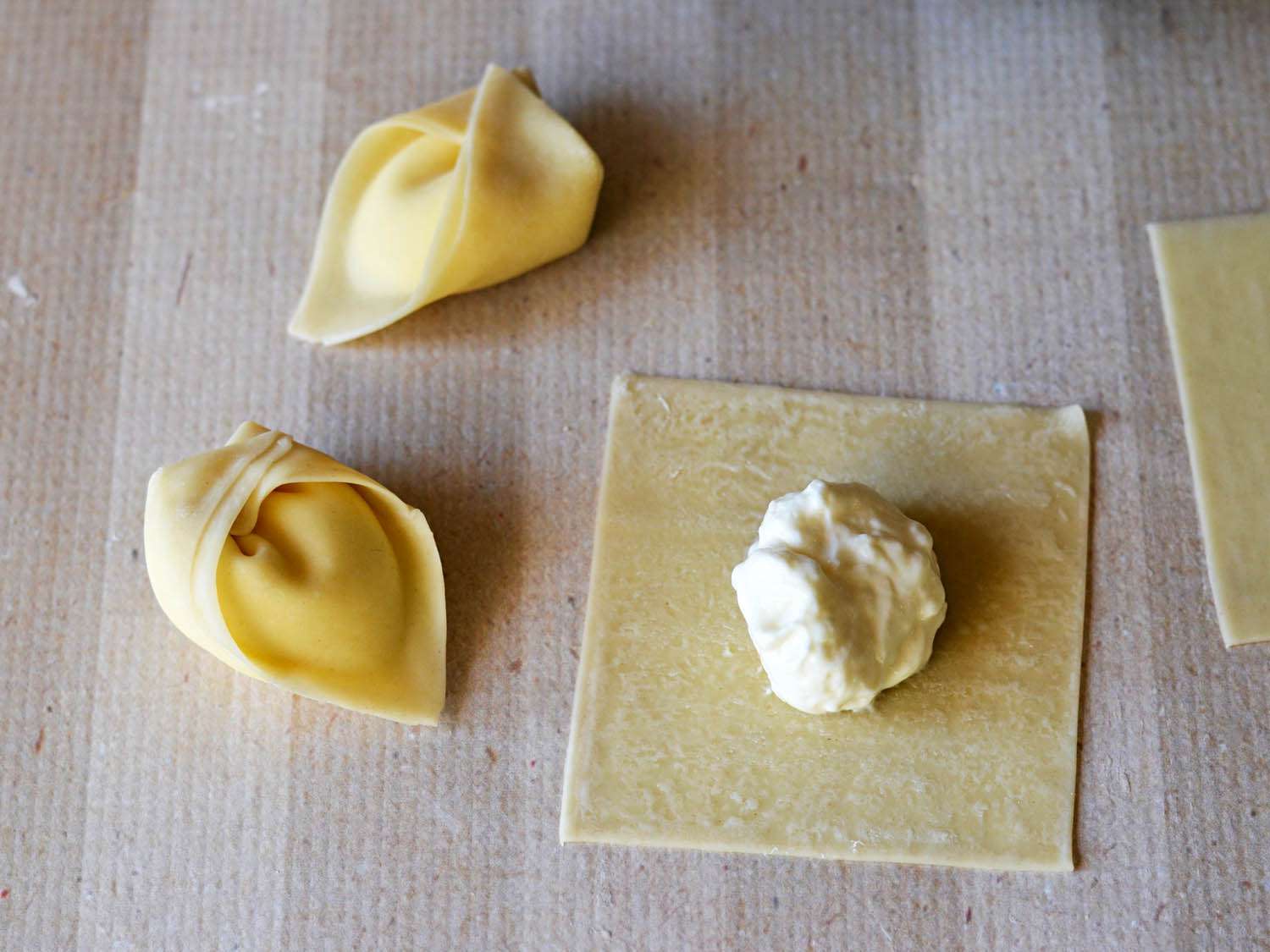 A wonton wrapper is filled, sealed, and folded.