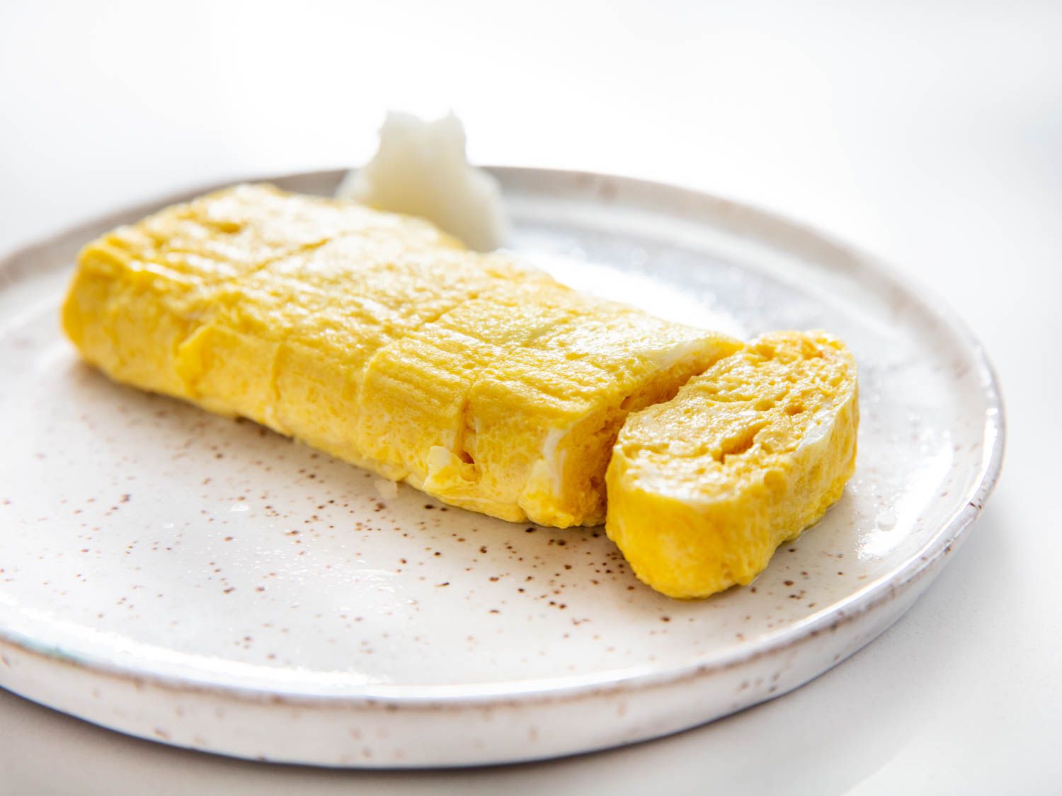 A plated home-style tamagoyaki, or Japenese rolled omelette, sliced crosswise into bite-sized pieces.