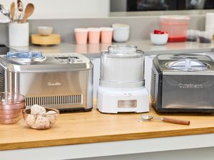 Three ice cream makers on a kitchen counter.