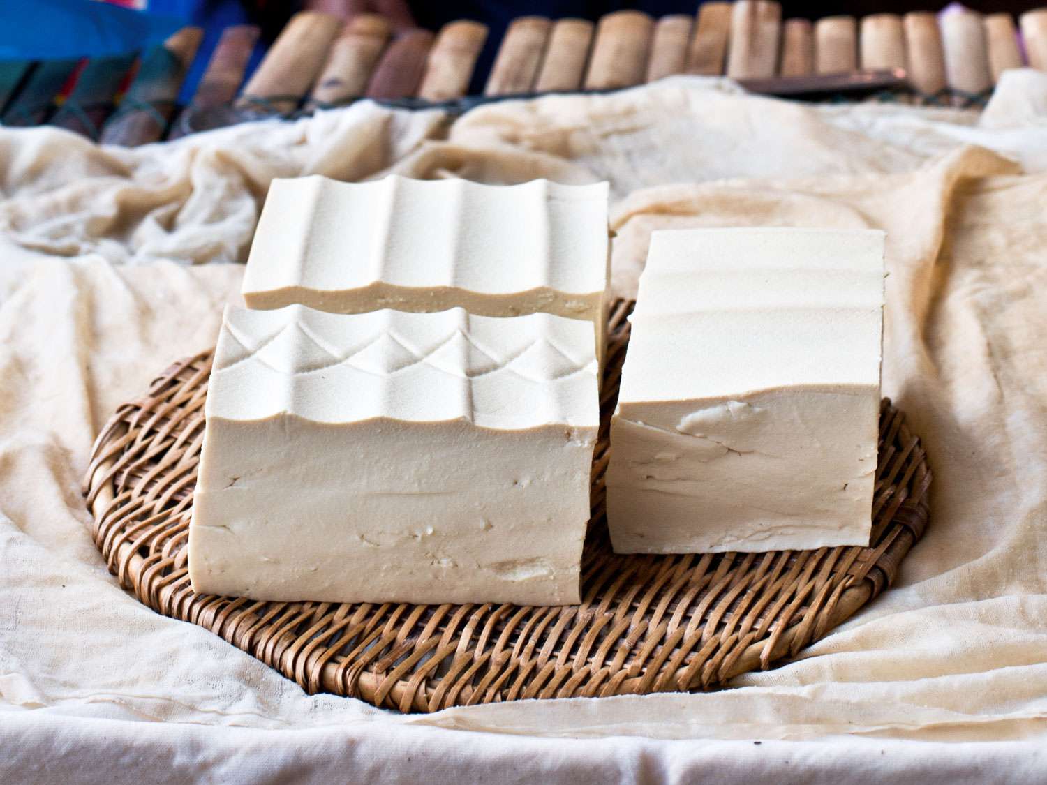 blocks of fresh tofu on a woven mat 