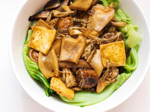Overhead view of braised mushrooms, tofu, and Chinese mustard greens 