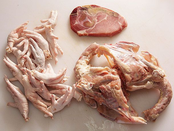 Jinhua ham, chicken carcass, and chicken feet on a white surface.