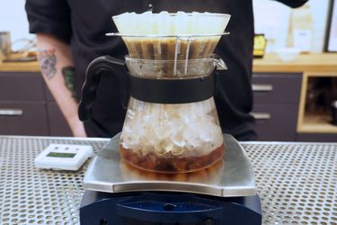 Iced coffee made in the Japanese style by brewing over a carafe of ice on a sacle.
