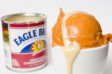 Scoop of Thai tea ice cream drizzled with sweetened condensed milk