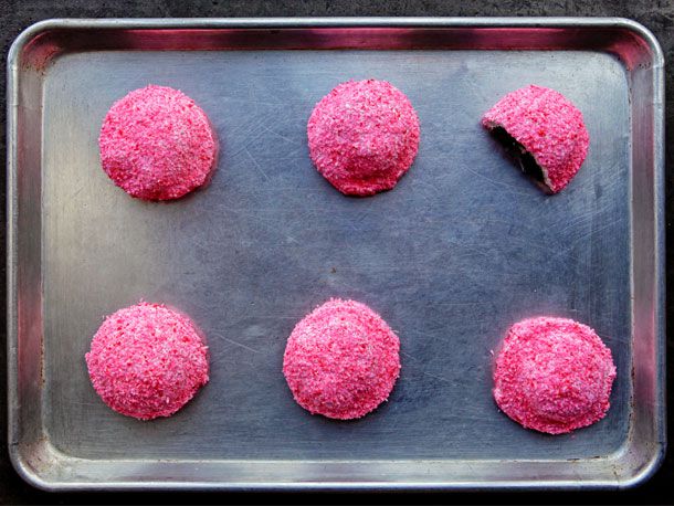 Overhead view of homemade sno balls on a rimmed baking sheet.