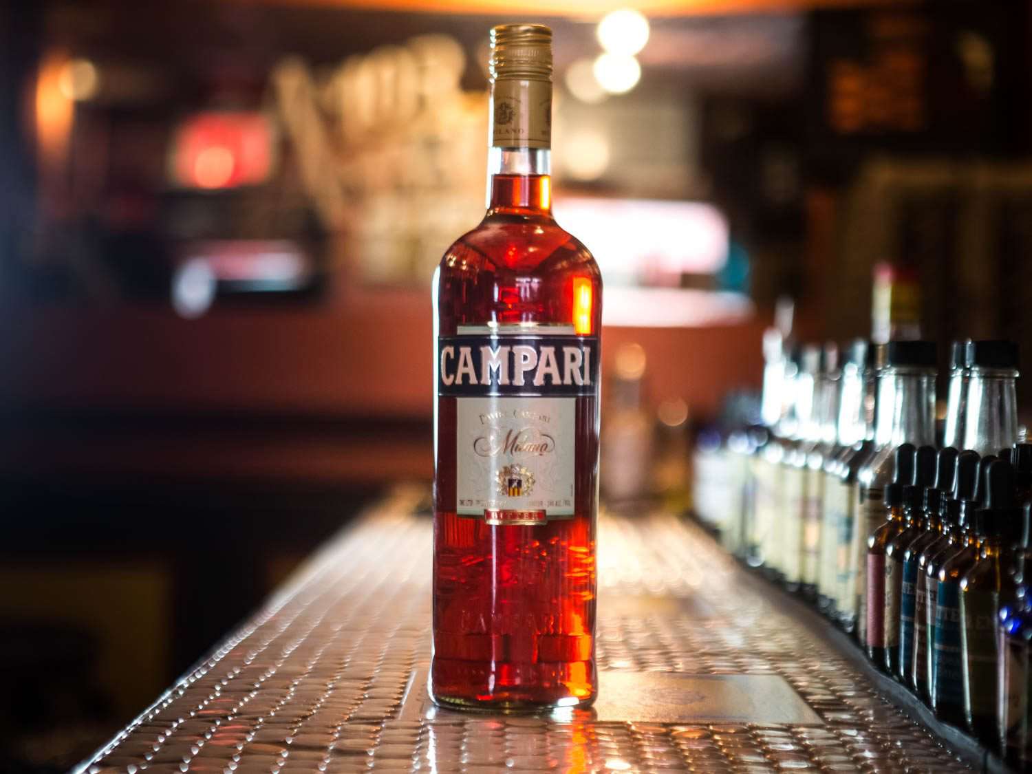 A bottle of Campari, a type of amaro, on a bar counter.