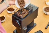 A person pours coffee beans into the Fellow Ode Gen 2 Coffee Grinder