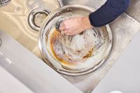 A person washes the Made In 12-Inch Stainless Steel Skillet in the sink