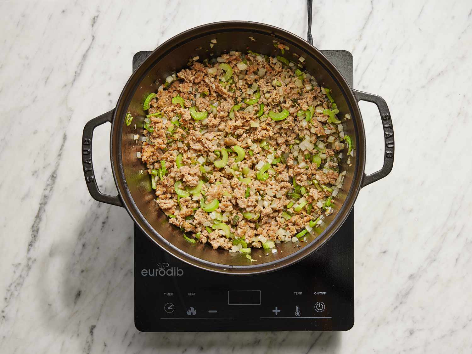 Sausage cooking in a large dutch oven