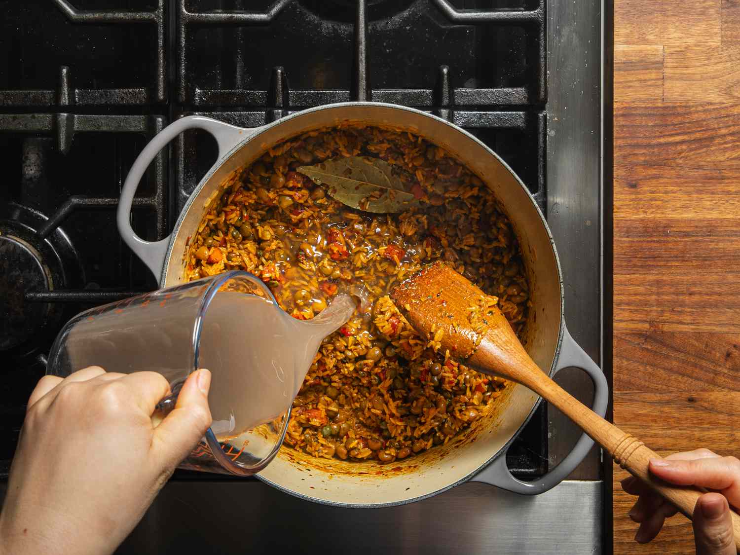 Overhead view of adding water to pea, rice and ham mixture