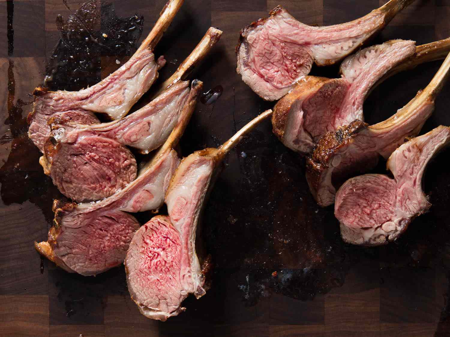 Six medium lamb chops resting on a cutting board. 