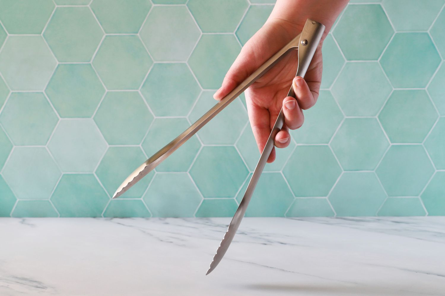 Hand holding the Material Kitchen The Only Tongs