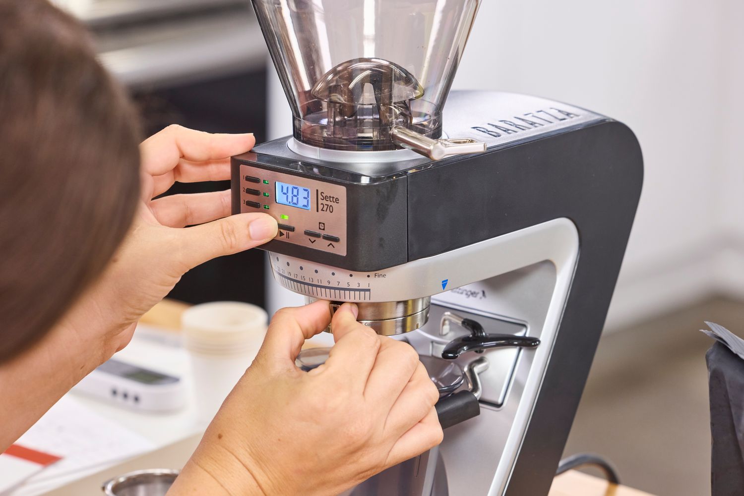 A person adjusts the grind setting on the Baratza Sette 270 Conical Burr Grinder