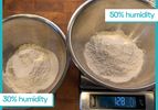 Two stainless steel bowls with flour labeled 30 and 50 humidity one placed on a digital scale displaying 128 grams