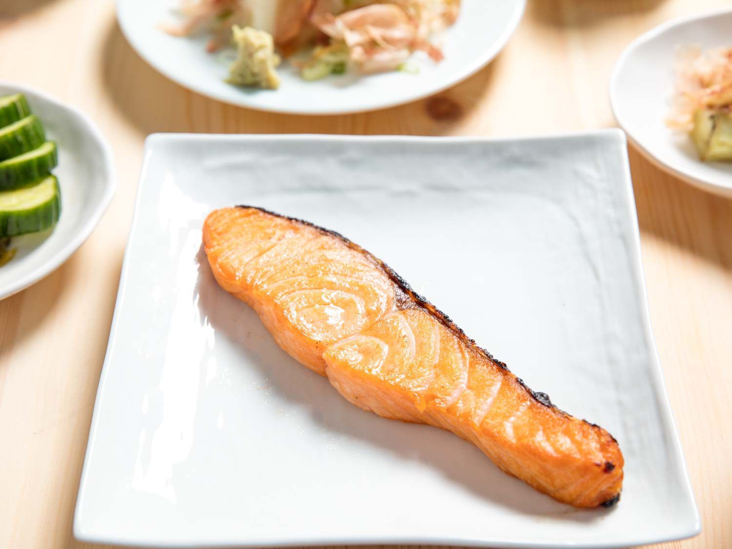 A piece of broiled salted salmon on a white plate