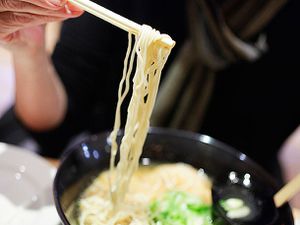Ramen being pulled from a bowl with chopsticks