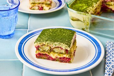 A plate with a slice of strawberry matcha tiramisu set on a table