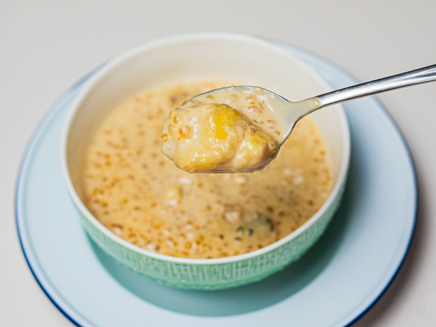 A spoon lifting Pengat Pisang