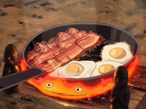 Bacon and eggs cook in a skillet over the flames of Calcifer (a fire demon).
