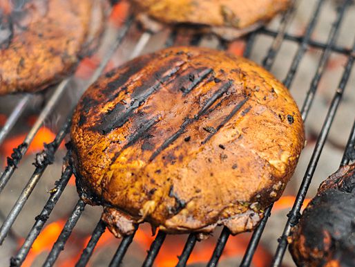 Closeup of the mushrooms cooking on the grill and lightly charring.