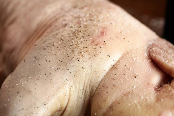 Sprinkling salt onto a suckling pig. 