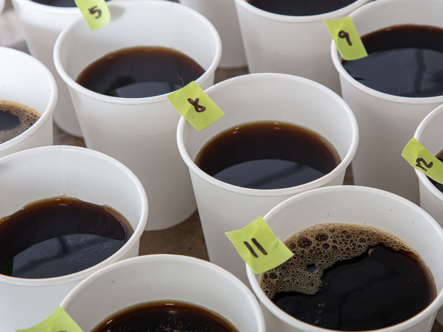 Several cups of coffee with numbered labels for a taste test