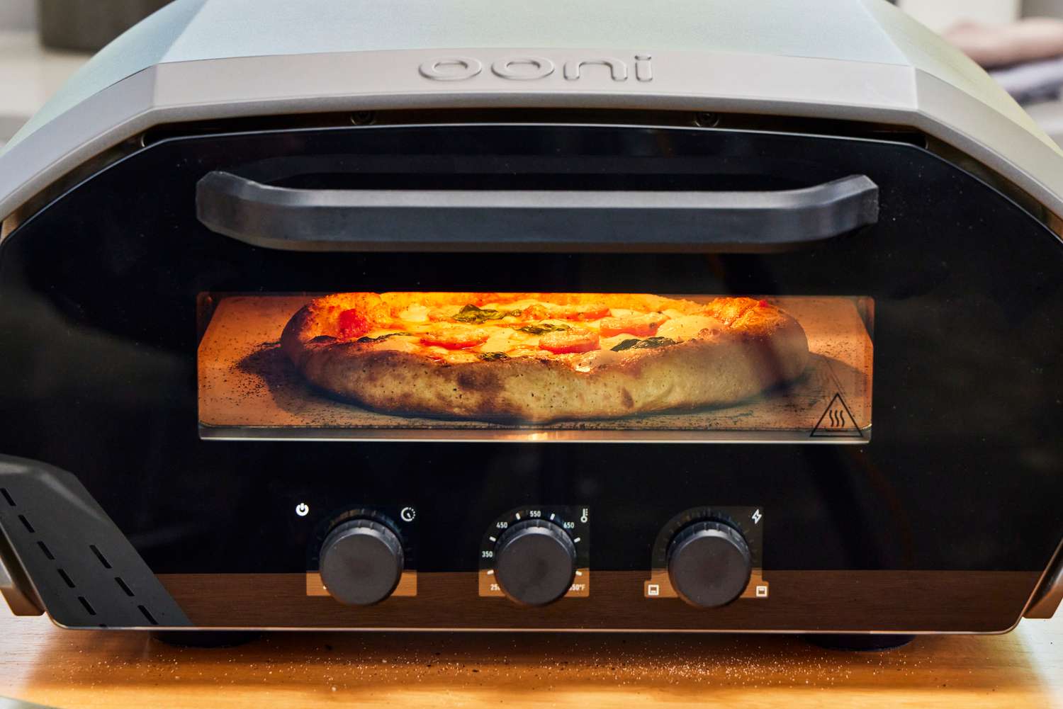A pizza cooks inside the Ooni Volt 12 Electric Pizza Oven