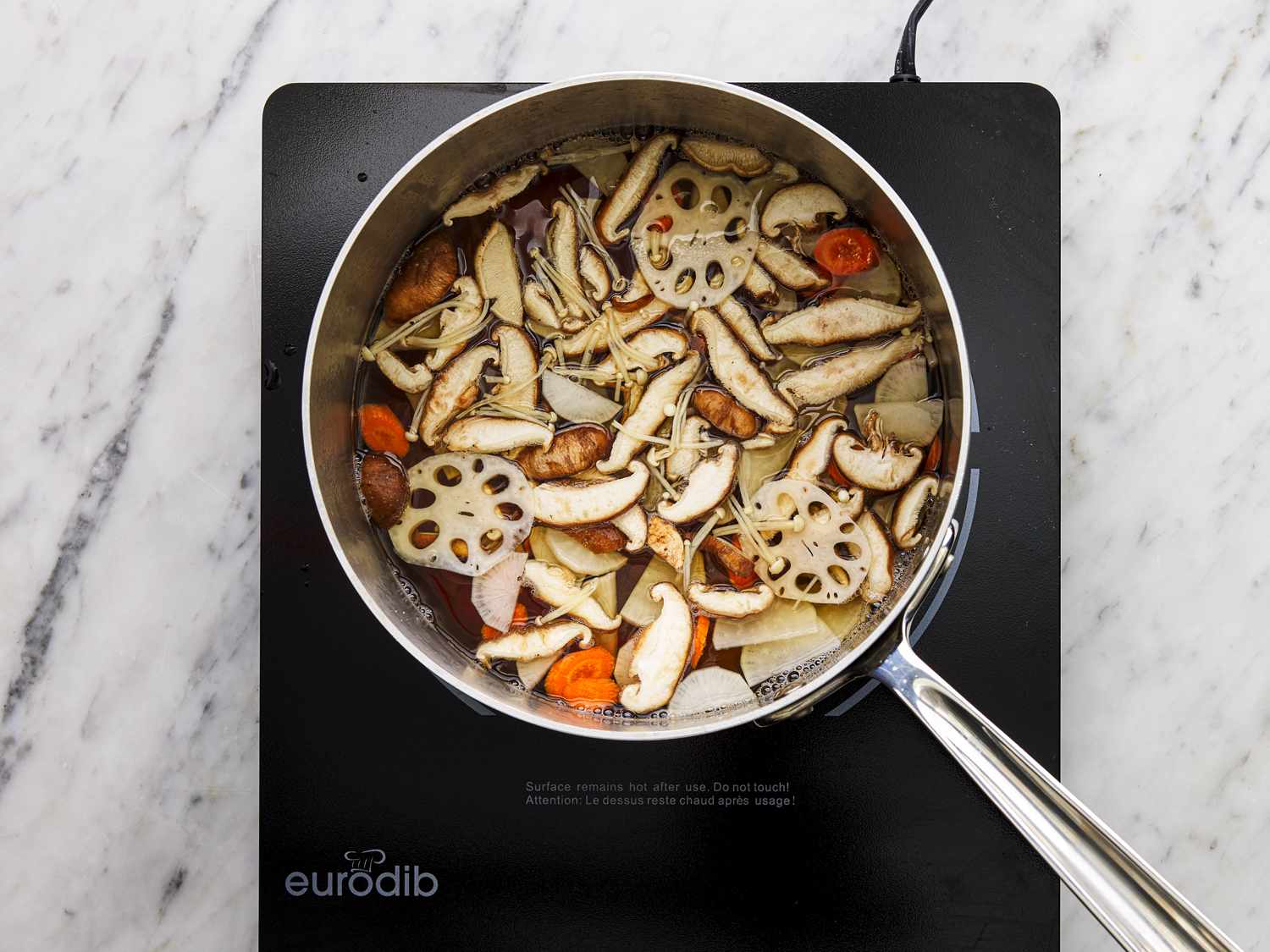 Overhead view of vegetables simmering in pot