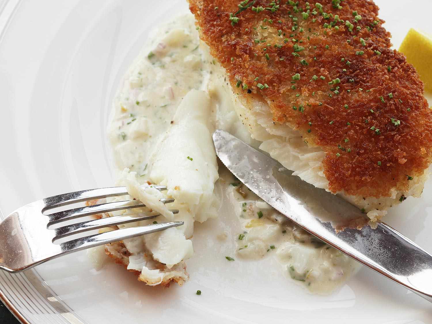 The fish fillet portion is cut into to reveal a tender, moist, and flaky interior.