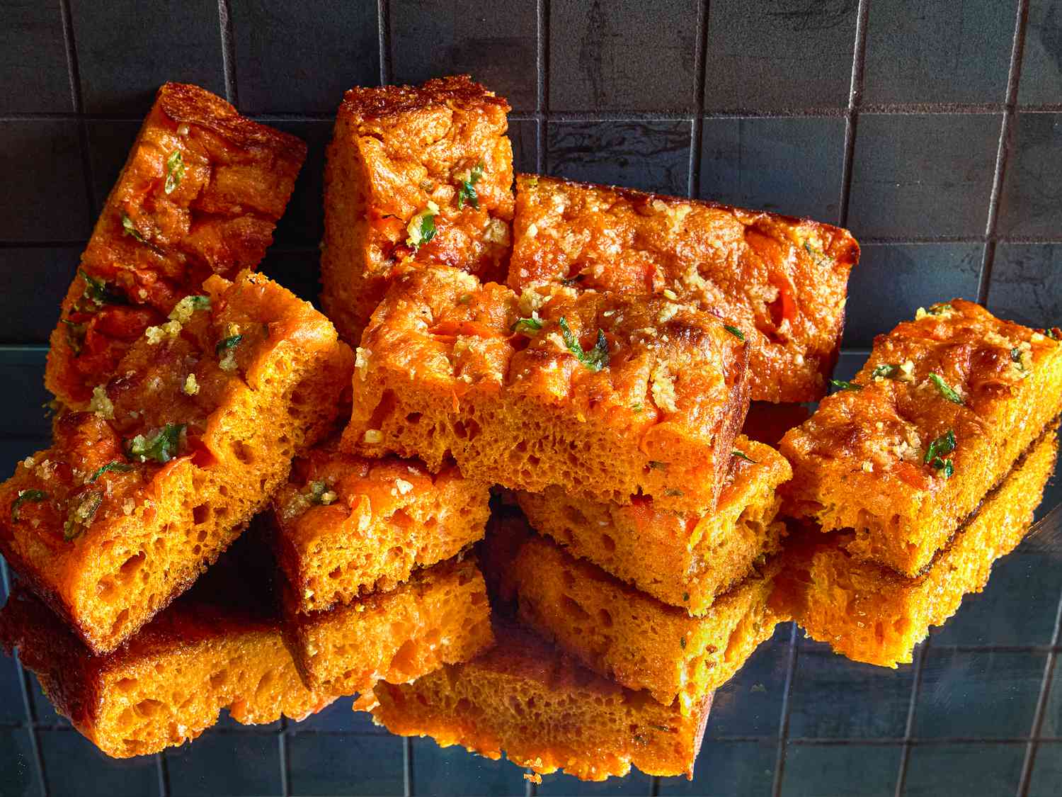Slices of carrot focaccia bread on a reflective surface
