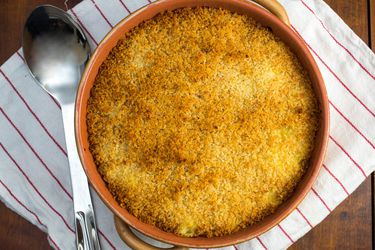 Overhead view of baked saffron risotto with mozzarella and crispy topping.