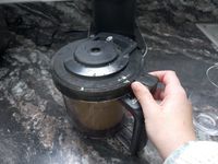 a person unlocking the lid on the Ninja creami