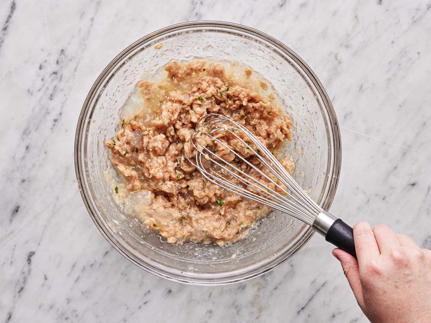 Overhead view of whisking together bone broth gel and pork mixture