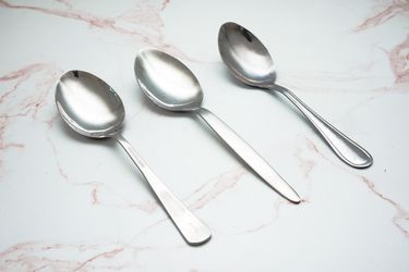 Sauce spoons on a pale pink marble countertop